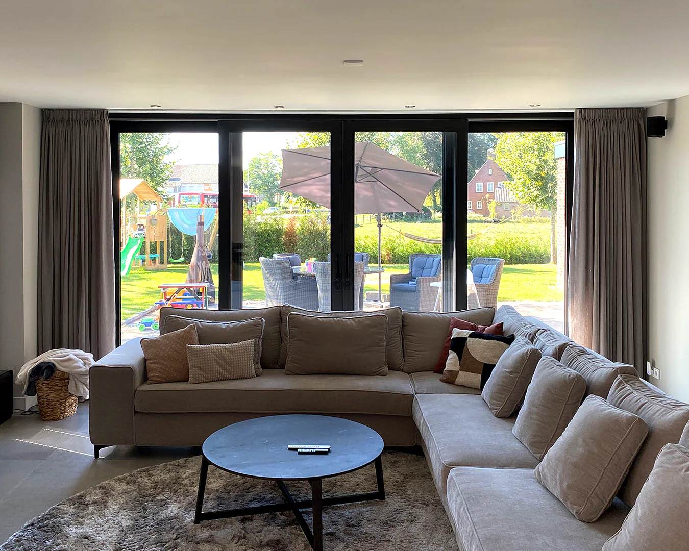 Vierdelige schuifpui vanuit de woonkamer naar tuin en terras van een Nederlandse woning